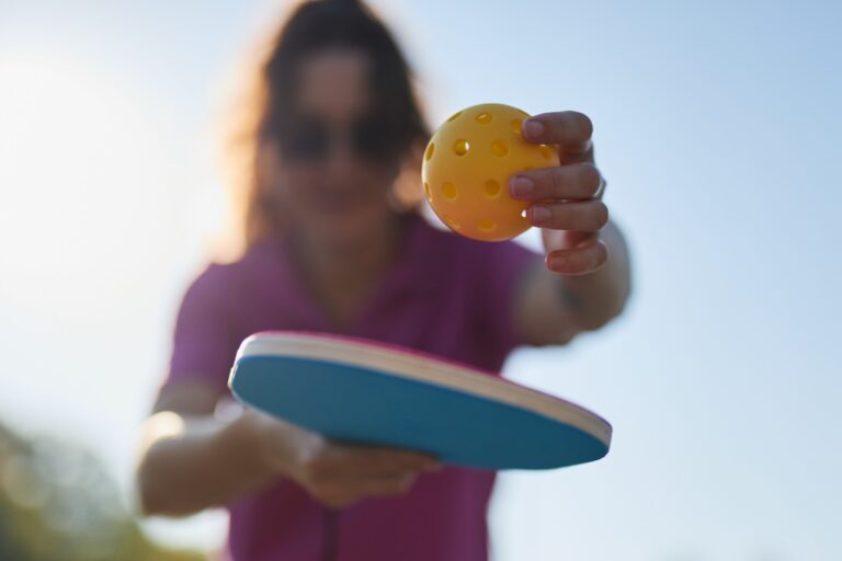 Imagen promocional con el texto "Aprende Pickleball", mostrando una pala de pickleball, una pelota amarilla y una cancha de fondo, invitando a iniciarse en este deporte